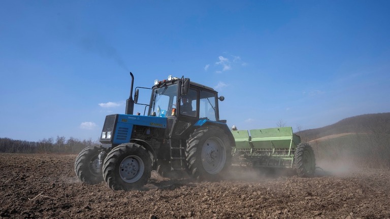 ウクライナ西部の村で小麦畑を耕す農業従事者/Nariman El-Mofty/AP