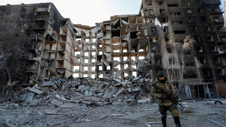 破壊された集合住宅のそばを歩く親ロシア派部隊の要員＝２８日、マリウポリ/Alexander Ermochenko/Reuters