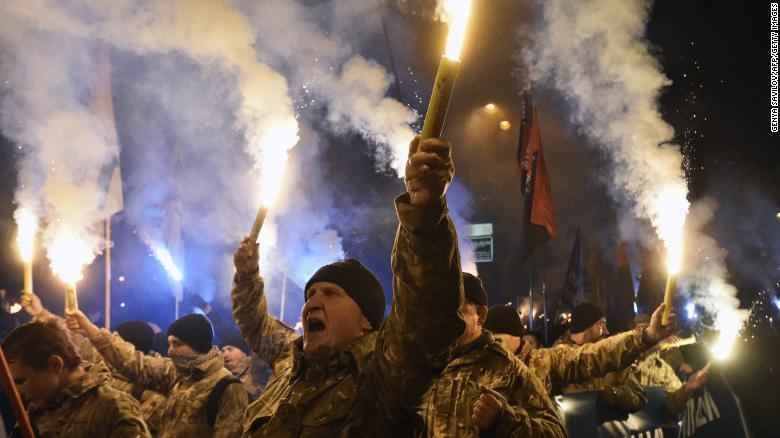 ２０１６年１０月１４日、「ウクライナ防衛者の日」の祝賀行事としてトーチを掲げ行進するアゾフ大隊の隊員と元兵士/Genya Savilov/AFP/Getty Images