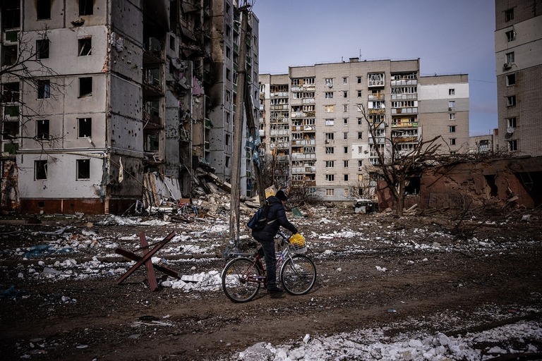 被害を受けた集合住宅の近くを自転車で走る男性＝３月４日、チェルニヒウ/Dimitar Dilkoff/AFP/Getty Images