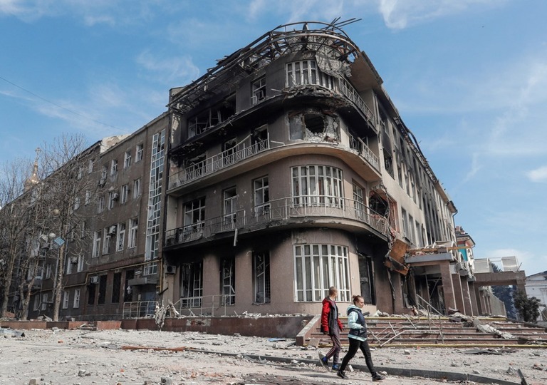 破壊された建物の近くを歩くマリウポリの住民/Alexander Ermochenko/Reuters