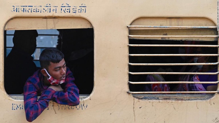 ムンバイの鉄道駅で長距離列車の窓から外を見る乗客/Indranil Mukherjee/AFP/Getty Images