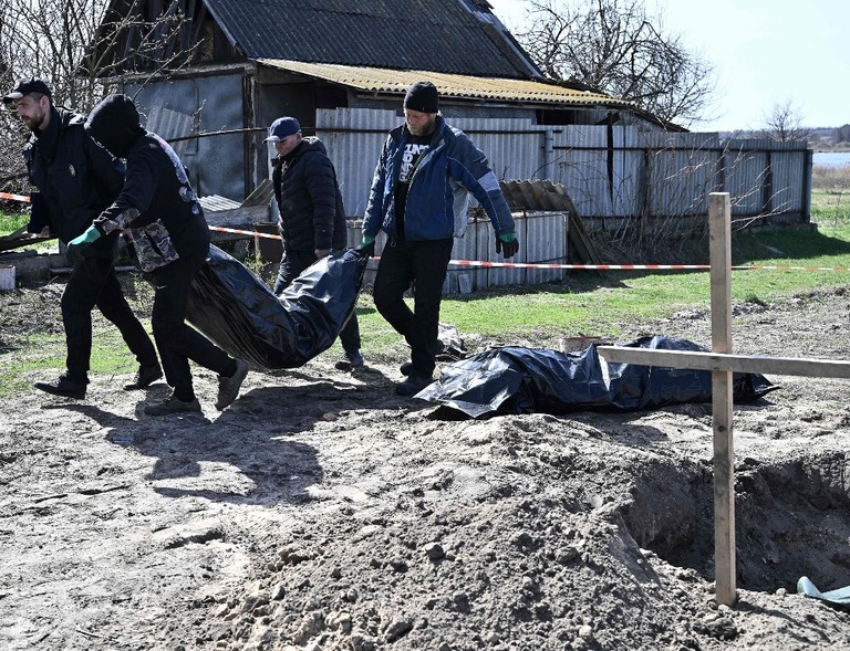 キーウ（キエフ）州の村の墓地から遺体２体を掘り起こす作業員ら＝４月１４日/Genya Savilov/AFP/Getty Images