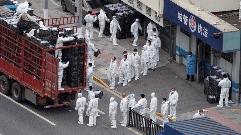 防護服を着た作業員が、上海の住民向けの食料や生活必需品を車両に積み込む/STR/AFP/Getty Images