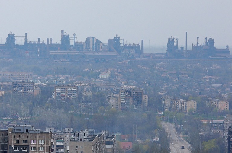 廃墟と化した共同住宅の向こうにそびえる製鉄所「アゾフスターリ」の施設群/Alexander Ermochenko/Reuters