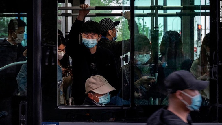 マスクを着用してバスを利用する人々＝２１日、中国・北京市/Kevin Frayer/Getty Images