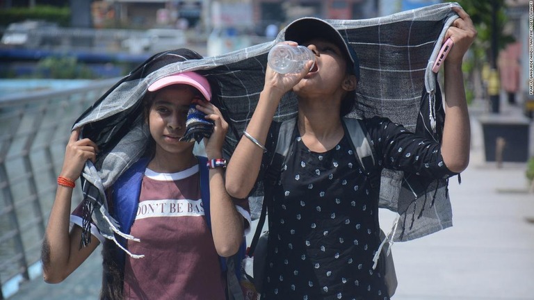 午後の暑さの中水を飲む人々＝インド・ムンバイ/Praful Gangurde/Hindustan Times/Getty Images
