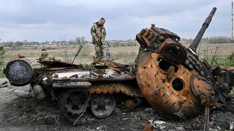 キーウ州の村の路上で破壊されたロシア軍の戦車を見つめるウクライナ軍の兵士/Genya Savilov/AFP/Getty Images