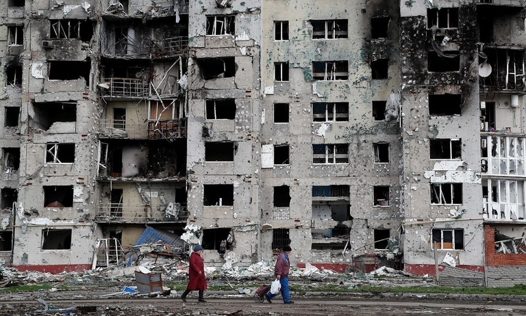 マリウポリの集合住宅前の通りを歩く人＝２２日/Alexander Ermochenko/Reuters