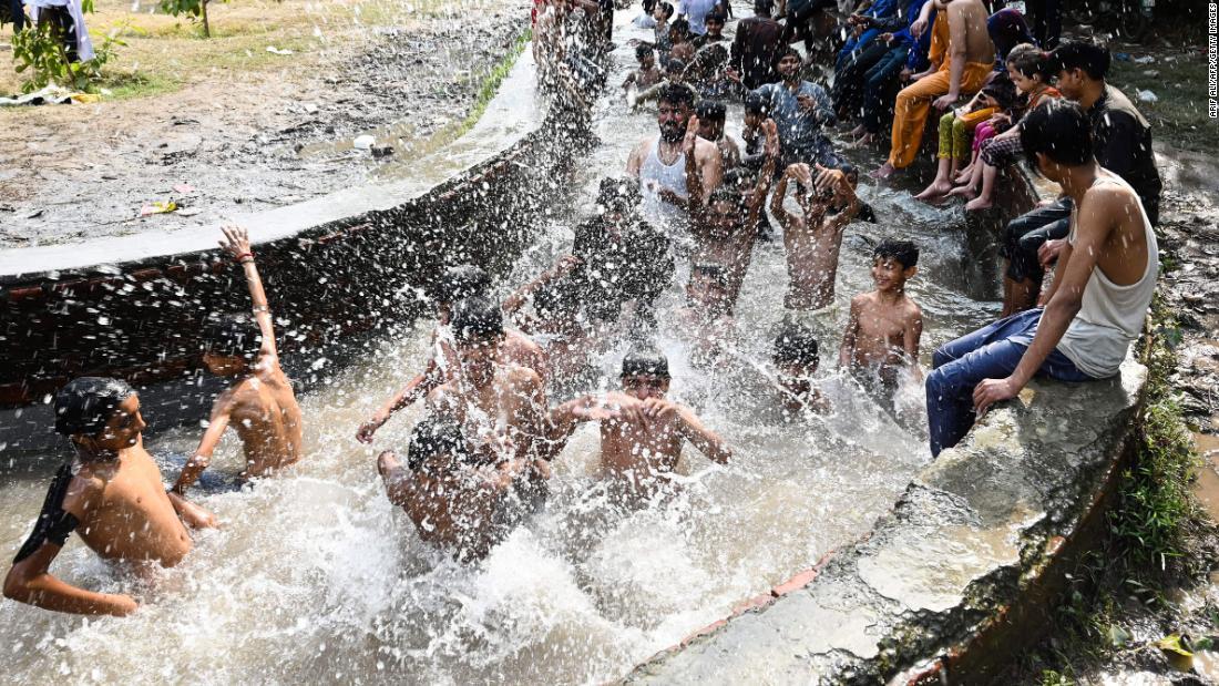 水路で涼を取る人々=4月29日、パキスタン・ラホール/ARIF ALI/AFP/Getty Images