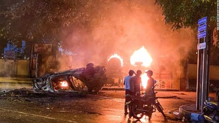 スリランカ首相の公邸付近で火を付けられ炎上する治安要員の車両とバス