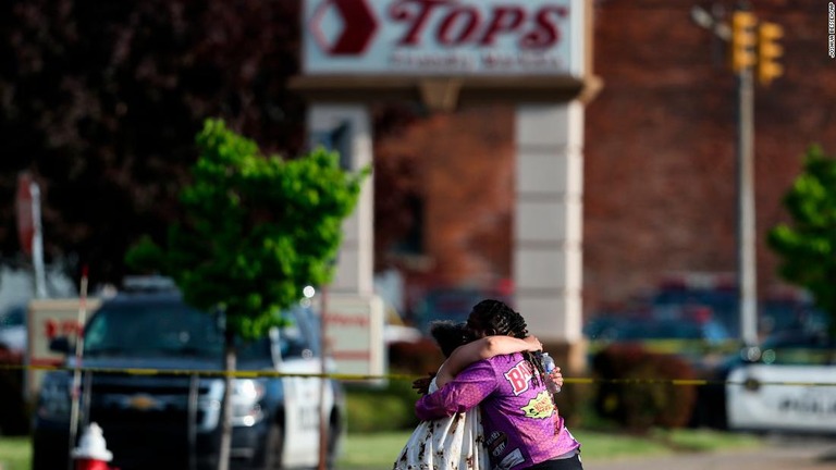 銃乱射の現場となった店の前で抱き合う人々＝１４日、米ニューヨーク州バファロー/Joshua Bessex/AP