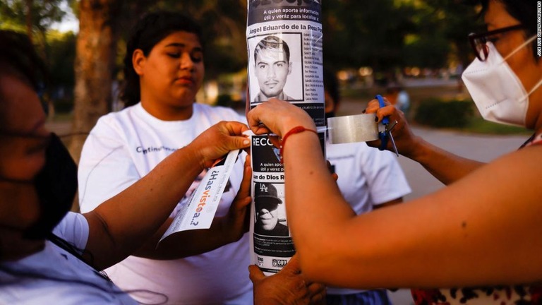 捜索についてのチラシを貼る行方不明者の親と活動家ら＝８日、メキシコ・シウダードファレス/Jose Luis Gonzalez/Reuters