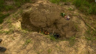 ミコラさんは穴の中で手足を縛られたまま、兄の遺体の下から地上へとはい出したという