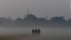 スモッグの中を歩く人々＝２０２１年１２月１５日、インド東部コルカタ