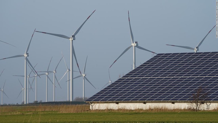 太陽光発電の屋根の奥には風力発電のタービンが並ぶ＝シュレスビヒホルシュタイン州/Marcus Brandt/picture alliance/Getty Images