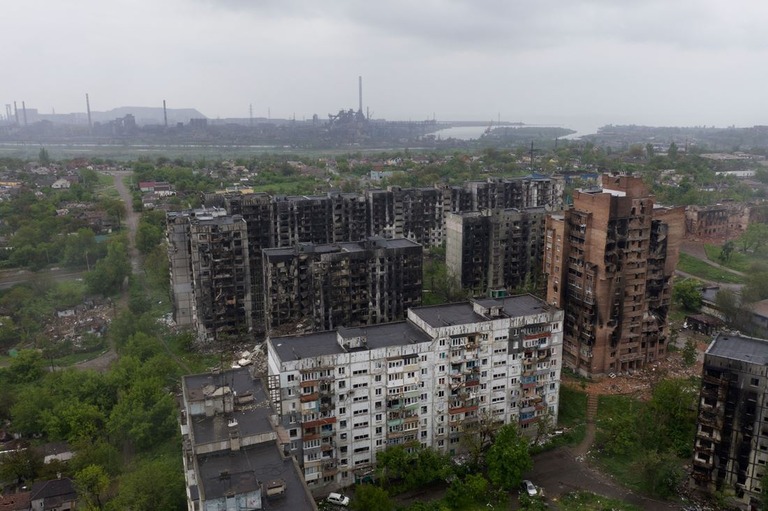 マリウポリの空撮画像。損壊した集合住宅の向こうにアゾフスターリ製鉄所が見える/Andrey Borodulin/AFP/Getty Images