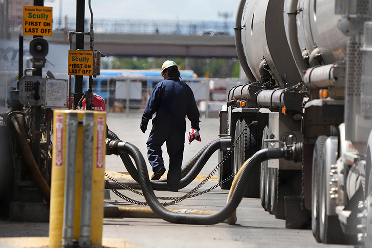 石油を輸送車から移す運転手＝２４日、米ソルトレークシティー/George Frey/Getty Images