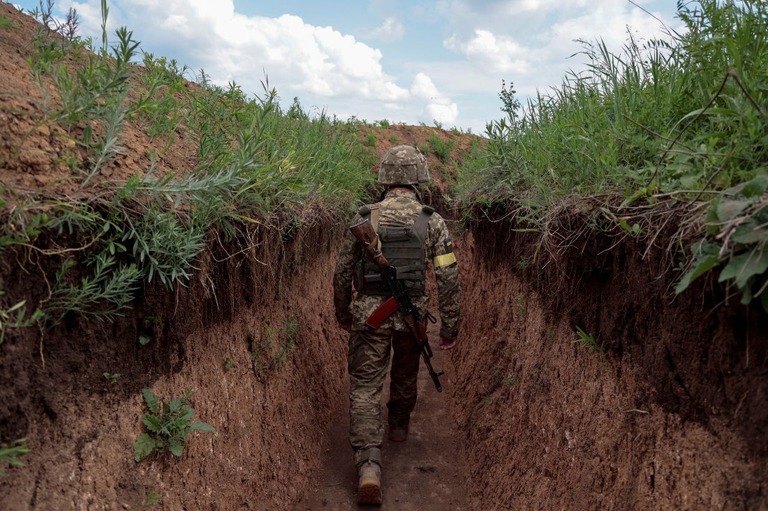 ドンバス地方の塹壕（ざんごう）の中を歩くウクライナ軍兵士＝２９日/Serhii Nuzhnenko/Reuters