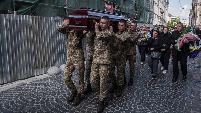 ウクライナ西部リビウでの戦死者の葬儀で棺を運ぶ兵士ら/Adri Salido/Anadolu Agency/Getty Images