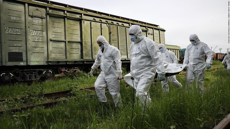 ロシア兵の遺体を運ぶ当局者ら＝キーウ（キエフ）、５月１３日撮影/Dogukan Keskinkilic/Anadolu Agency/Getty Images