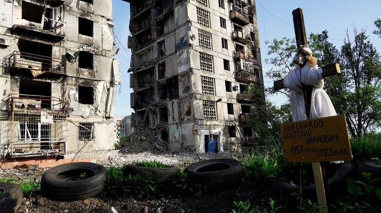 破壊された住宅の前につくられた墓＝５月３１日、ウクライナ・マリウポリ/AFP/Getty Images