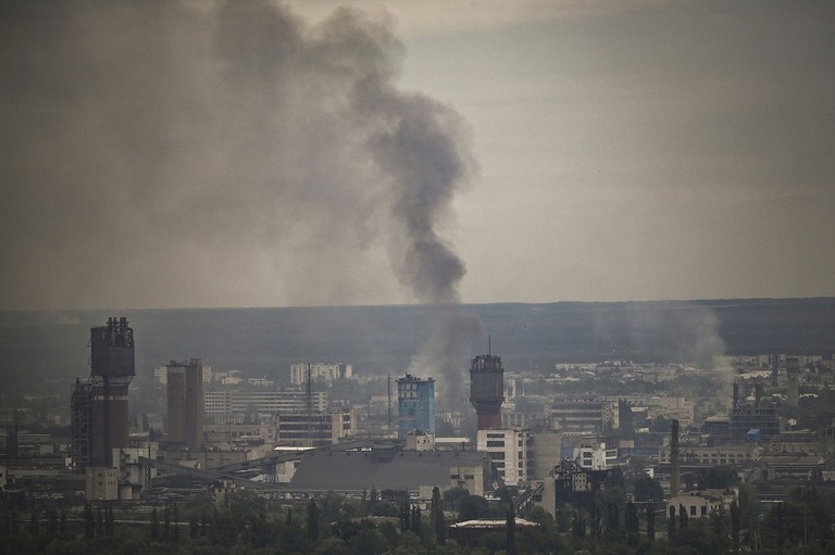 煙が立ち上る町＝１３日、ウクライナ東部ルハンスク州セベロドネツク市/Aris Messinis/AFP/Getty Images