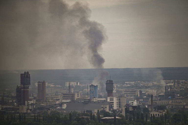 煙が立ち上る町＝１３日、ウクライナ東部ルハンスク州セベロドネツク市/Aris Messinis/AFP/Getty Images