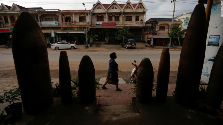 ベトナム戦争中、米軍によって大量の爆弾を投下されたラオスの街を歩く女性/Jorge Silva/Reuters