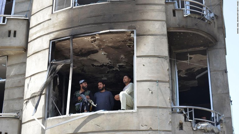 襲撃を受けた建物を調べるタリバンの戦闘員ら＝１８日、アフガニスタン首都カブール/Ahmad Sahel Arman/AFP/Getty Images