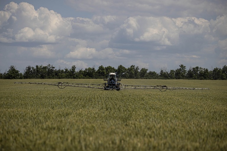 オデーサの小麦畑で、農業機械を駆使して作業する農業従事者/Metin Aktas/Anadolu Agency/Getty Images