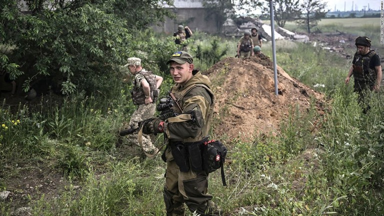 リシチャンスク市郊外で、空爆後の状況を調べるウクライナ軍の兵士ら/Aris Messinis/AFP/Getty Images
