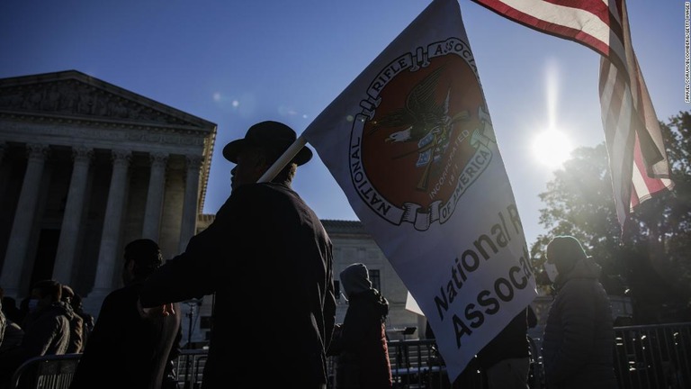 合衆国憲法修正第２条の支持者が米国旗と全米ライフル協会の旗を持って連邦最高裁前を行進＝２０２１年１１月３日/Samuel Corum/Bloomberg/Getty Images