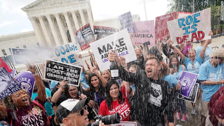 最高裁前でシャンパンを開けて祝う反中絶デモの参加者/Steve Helber/AP