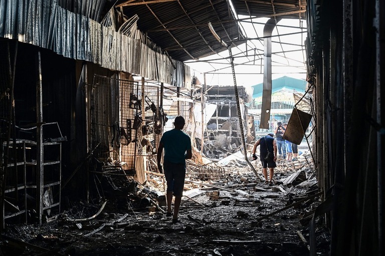 ドネツク州スラビャンスク中心部の破壊された市場を歩く人＝６日/Miguel Medina/AFP/Getty Images