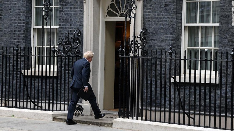 辞任を表明後、官邸内に戻ろうとする英国のジョンソン首相/Daniel Leal/AFP/Getty Images