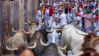 ３年ぶりに復活したスペイン・パンプローナ伝統の牛追い祭りで牛の前方を走る人々