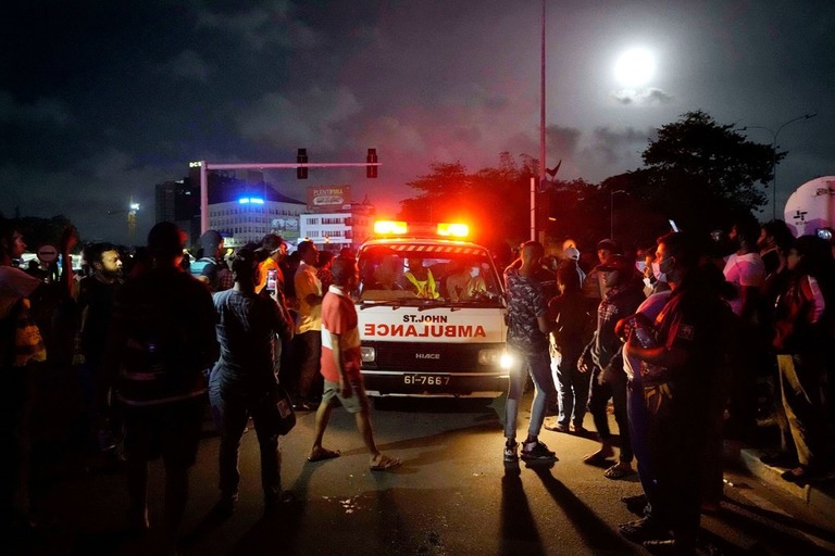 議会付近での警察との衝突後負傷者を運ぶ救急車と抗議デモ参加者＝１３日、コロンボ/Eranga Jayawardena/AP