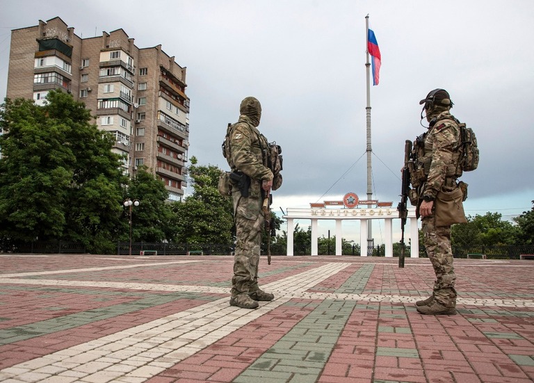 ザポリージャ州メリトポリ中心部の広場を警備するロシア軍の兵士/Sergei Ilnitsky/EPA-EFE/Shutterstock