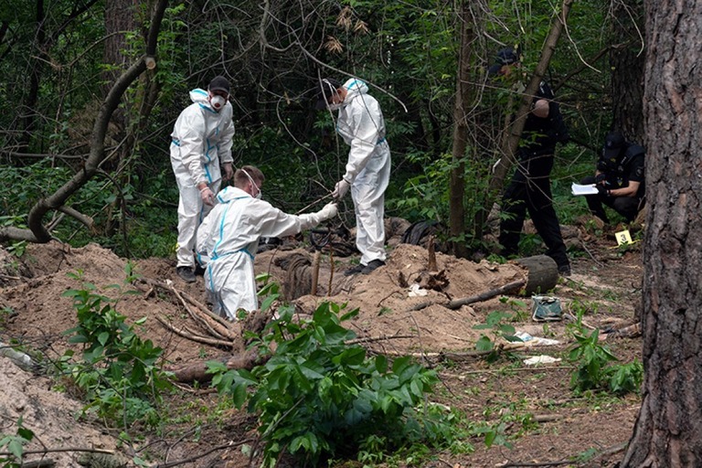 ロシア兵に殺害された民間人の遺体発見現場を調査する捜査官＝６月１３日、ウクライナ・ブチャ