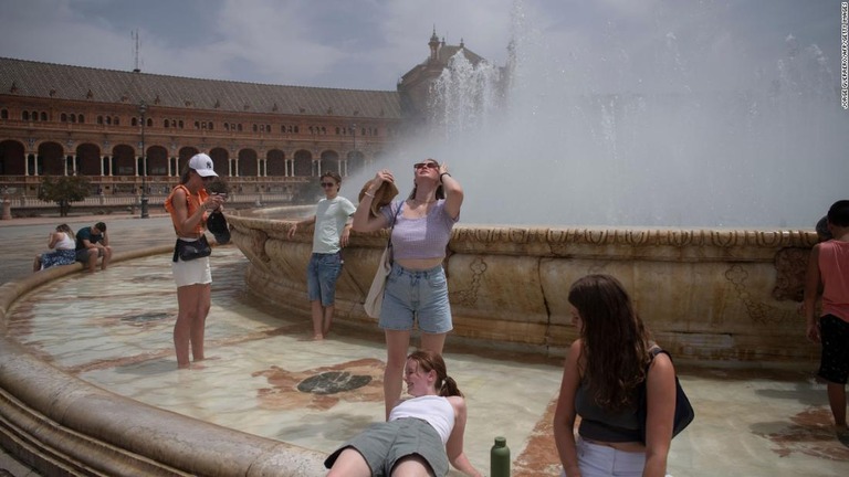 噴水で涼む人々＝１２日、スペイン・セビリア/Jorge Guerrero/AFP/Getty Images