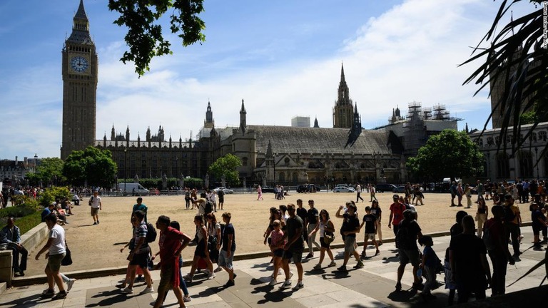 太陽が照り付けるなか、ロンドン市内を歩く観光客/Leon Neal/Getty Images