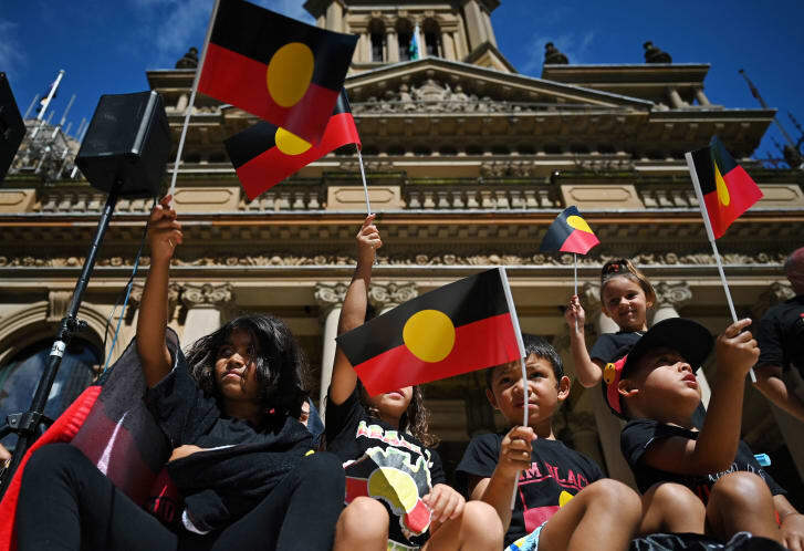 「オーストラリアの日」にあわせて先住民の旗を掲げて講義する人々＝１月２６日、オーストラリア・シドニー/Steven Saphore/AFP/Getty Images