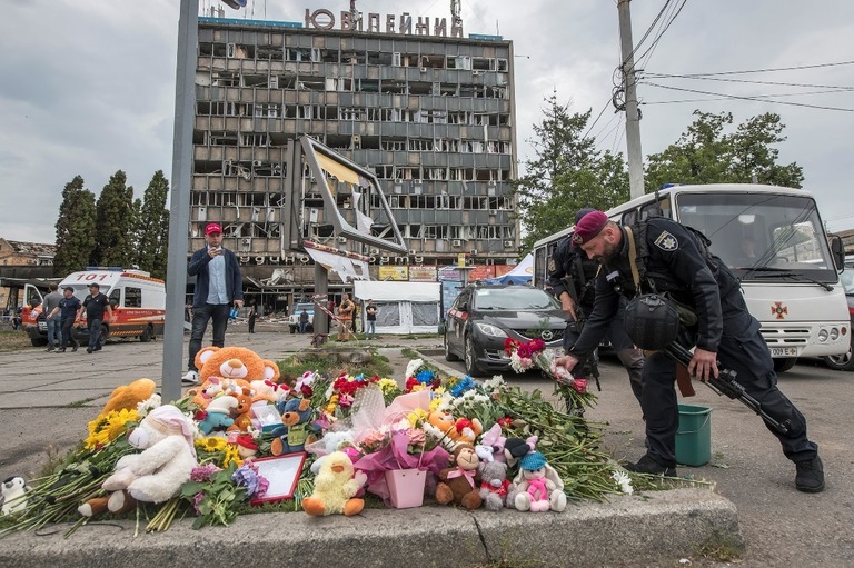 ウクライナ中部ビンニツァのロシアによるミサイル攻撃の現場に花や玩具を供える兵士/Maxym Marusenko/NurPhoto/Getty Images
