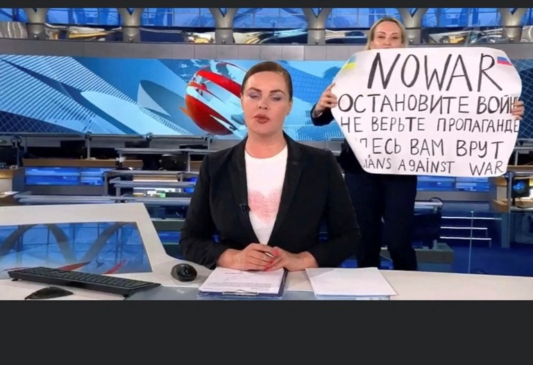 国営テレビ放送中に「戦争反対」などと書かれた紙を掲げるマリーナ・オフシャニコワ氏/Stella Pictures/Abaca/Sipa USA/AP