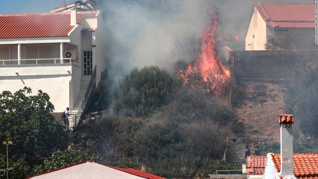 住宅地のすぐ近くで火の手が上がる/MANOLIS LAGOUTARIS/AFP/Getty Images