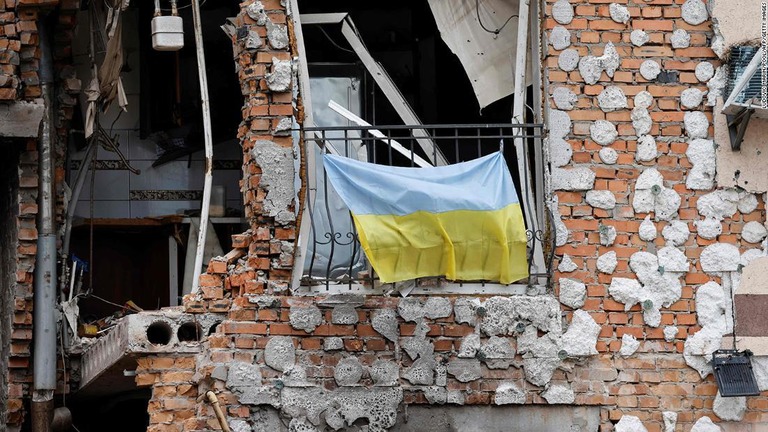 破壊された建物に掲げられたウクライナ国旗＝６月１６日、ウクライナ・イルピン/Ludovic Marin/Pool/AFP/Getty Images