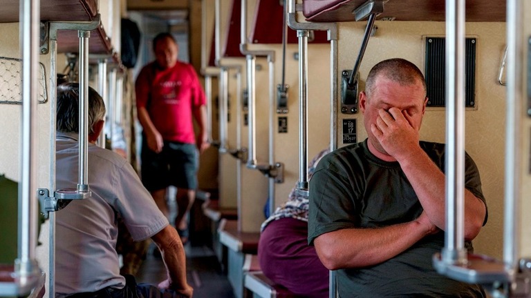 列車でウクライナ東部から西部へと避難する人たち＝２日/David Goldman/AP