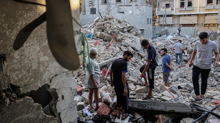 ガザ南部ラファでイスラエル軍の空爆後に建物の被害を確認する人々＝７日/Said Khatib/AFP/Getty Images