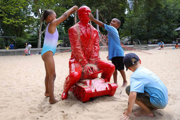 プーチン大統領の像に砂をかける子どもたち/Andrew Kelly/Reuters